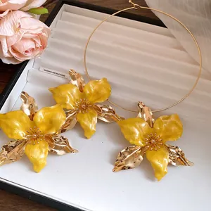 Detailed macro shot of vintage yellow enamel flower earrings and matching gold choker