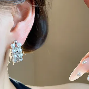 Close-up of elegant French vintage silver needle pearl and zircon earrings