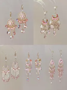 Detailed view of various pink crystal tassel and butterfly ethnic style earrings