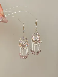 Close-up detail of luxury palace style drop earrings with rhinestones and pearl tassels