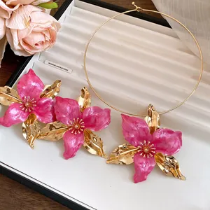 Close-up detail of vintage pink enamel flower earring and gold choker jewelry set