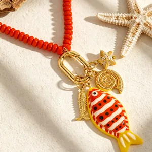 Detalle macro de collar de cuentas con tema oceánico y dijes de peces y estrellas de mar