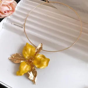 Vintage gold-toned choker necklace featuring a large yellow enamel flower pendant