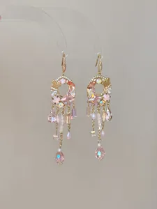 Detail view of elegant palace style tassel dangling earrings with pink crystals and pearls