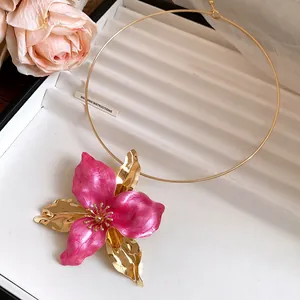 Close-up of vintage pink enamel flower collar necklace with elegant gold plating