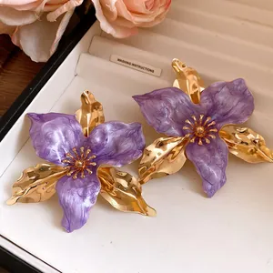 Close-up of purple and gold floral vintage earrings with enamel texture