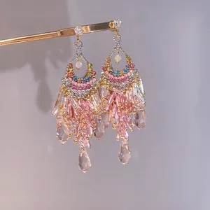 Detailed view of luxury pink glass tassel earrings with chandelier drop design