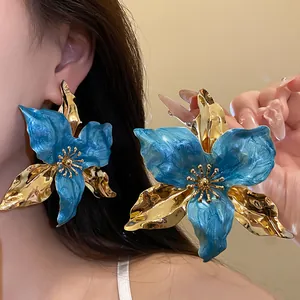 Elegant close-up of vintage oversized blue enamel floral earrings with luxury gold accents