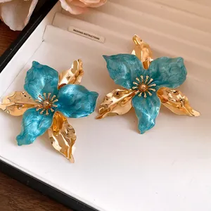 Close-up of elegant vintage court-style turquoise enamel and gold flower statement earrings