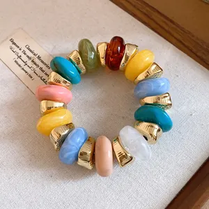 Detailed view of a colorful marble-textured resin bracelet with gold-tone spacers