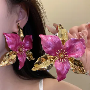 Detailed close-up view of vintage fuchsia pink enamel and gold oversized flower earrings