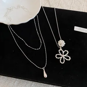 Close-up detail view of double-layer water drop and pearl flower pendant necklaces