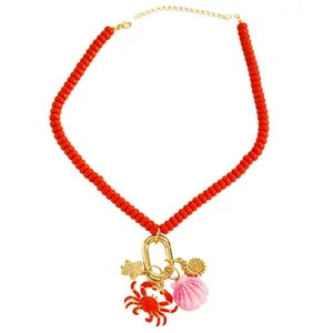 Collar de cuentas naranja vibrante con dijes detallados de cangrejo, concha y estrella de mar.
