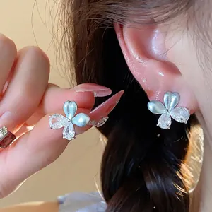 Élégantes boucles d'oreilles fleur avec zircon et pétales en émail bleu sur modèle