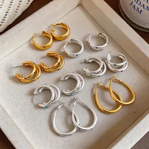 Pendientes de aro minimalistas de metal cepillado con lunares en oro y plata.