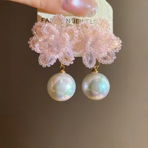 Eleganti orecchini a perno con fiori di cristallo rosa e grandi perle iridescenti.