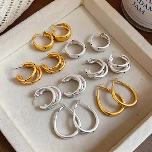 Colección de pendientes de aro mate en oro y plata con lunares y diseños de capas únicas.