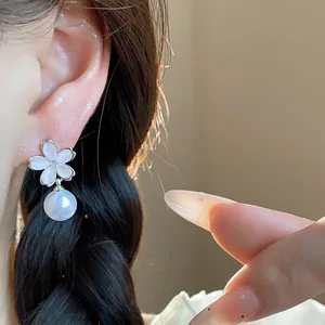 Detailed close-up view of elegant zircon flower stud earrings with white pearl drop
