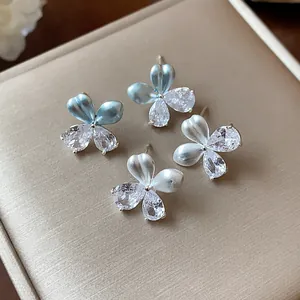 Vue détaillée de boucles d'oreilles fleurs en argent avec zircons et émail élégants