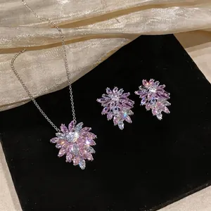 Elegant zircon flower pendant necklace and earrings set displayed on black velvet pad
