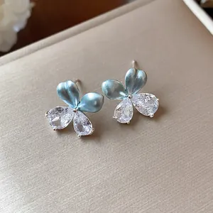 Vue détaillée de boucles d'oreilles fleurs en émail bleu et zircons en forme de goutte