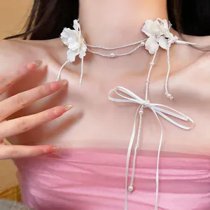 Vista dettagliata della collana choker con fiori bianchi, perle e perline stile fata