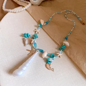 Detail view of a ocean-style necklace with starfish and turquoise beads on a beige surface