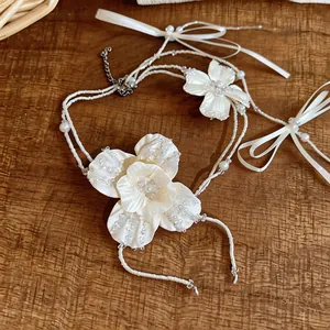 Primo piano di un'elegante collana di fiori con perline di vetro bianco e perle fini