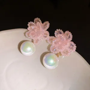Primo piano di orecchini a fiore in perle di cristallo rosa con perle iridescenti