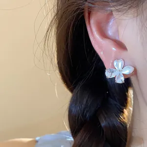 Gros plan d'une boucle d'oreille papillon en argent avec zircon et détails goutte d'huile