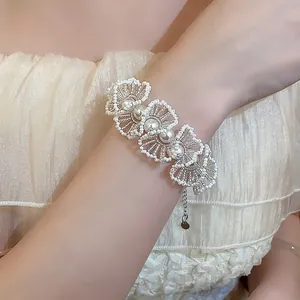 Close-up of elegant beaded lace flower bracelet with white pearls and glass beads