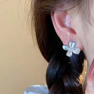 Détail d'une boucle d'oreille fleur minimaliste avec zircons et finition émail
