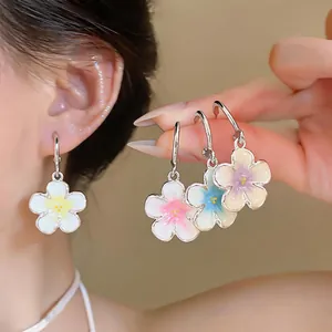 Primo piano di orecchini a cerchio a forma di fiore in smalto pastello