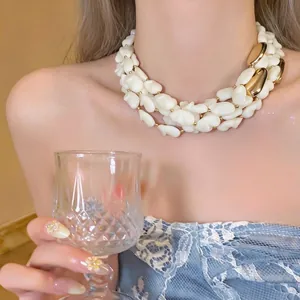 Élégant collier de perles blanches avec un design luxueux en patchwork de métal doré