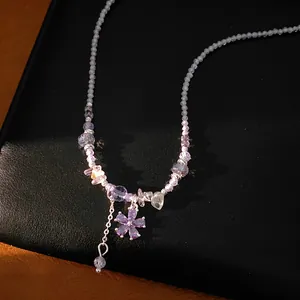 Close-up of elegant purple glass beaded necklace featuring a zircon flower pendant.