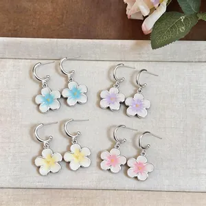 Dettaglio di quattro paia di orecchini a cerchio a forma di fiore in smalto colori pastello.