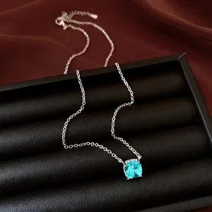 Minimalist square turquoise zircon pendant necklace with silver chain on black jewelry tray.