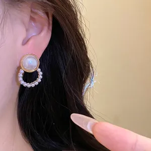 Elegant round pearl stud earrings with a circular pearl drop for a refined look.