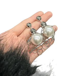 Elegant metal chain link earrings with large white pearls in a retro niche design.