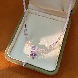 Detailed view of the purple glass bead necklace featuring a sparkling zircon flower pendant