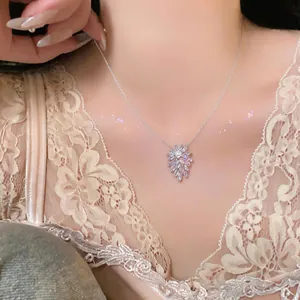 Close-up of elegant silver necklace with sparkling zircon flower pendant on neck