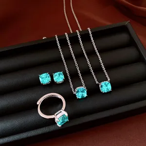 Close-up of elegant turquoise cushion-cut zircon jewelry set on black display tray