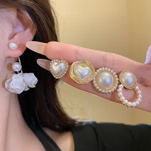 Close-up of elegant pearl earrings featuring heart shapes and crystals on S925 silver studs