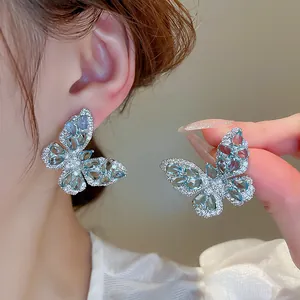 Elegant silver butterfly ear studs featuring light blue water-drop shaped crystals