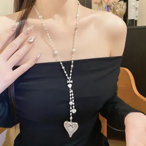 Close-up of elegant pearl and metal beaded necklace with heart pendants