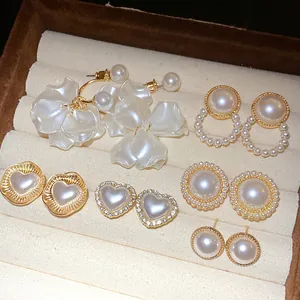 Detailed view of various elegant pearl and heart-shaped stud earring styles in jewelry box