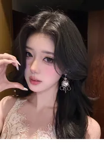 Detailed view of niche designer vintage style pearl and metal chain earrings on a model