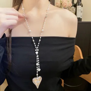 Elegant adjustable Y-shaped pearl strand necklace with silver heart pendant on Asian model.