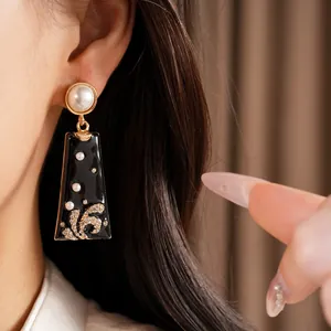 Detail shot of vintage black enamel drop earrings with pearls and rhinestones