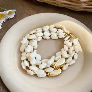 Vue détaillée du collier multi-rangs en nacre blanche avec fermoir en métal doré élégant